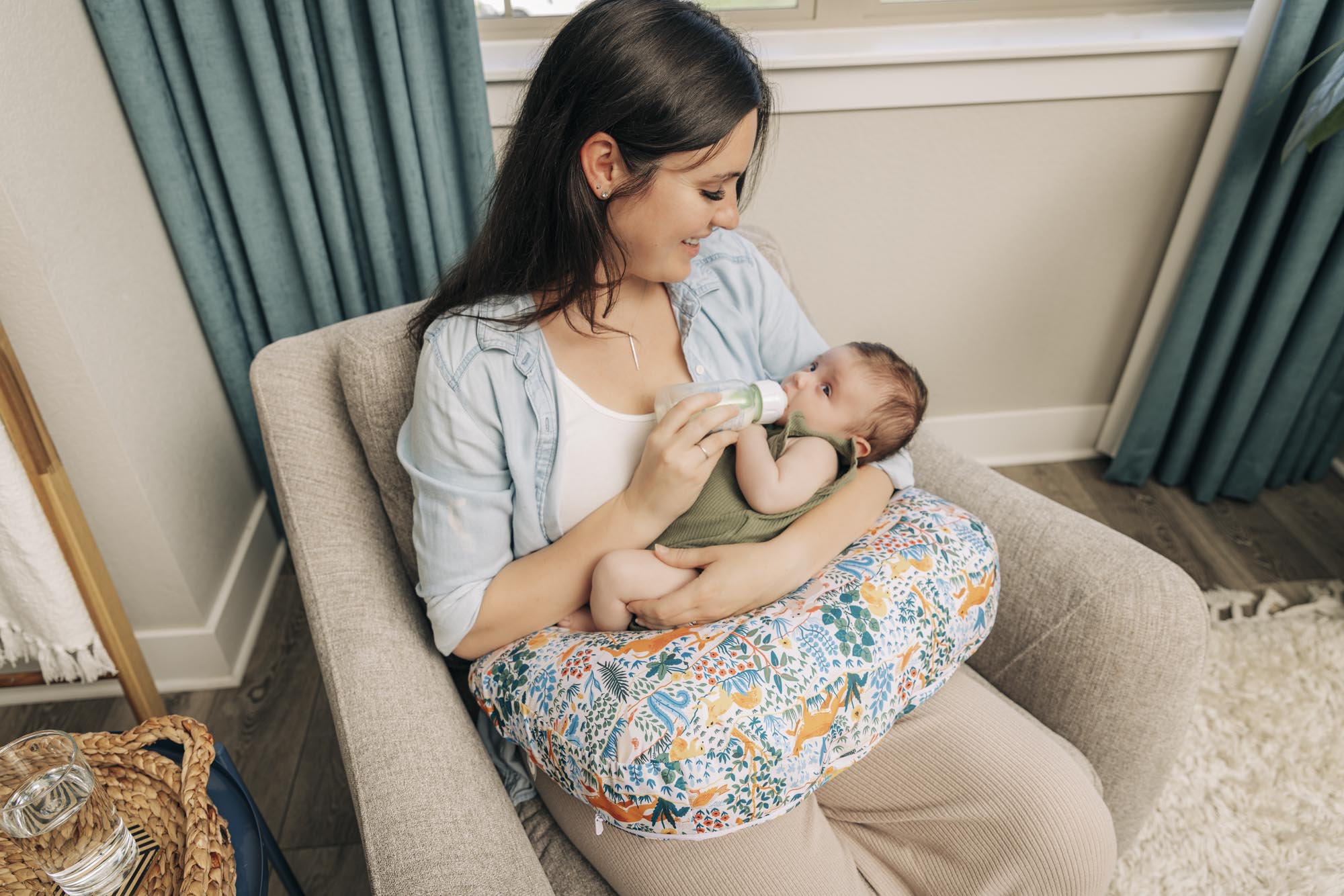 mom bottle feeding baby with nursing pillow