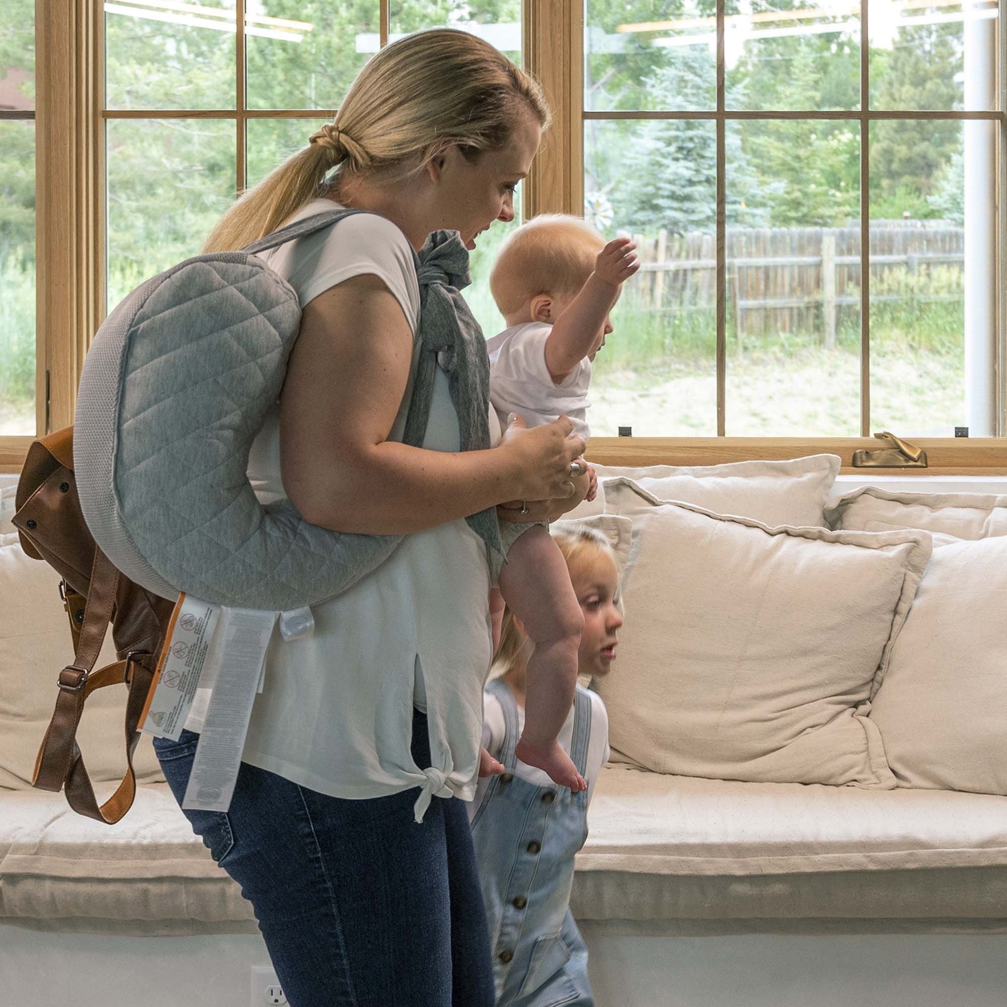 woman carrying travel nursing pillow with kids