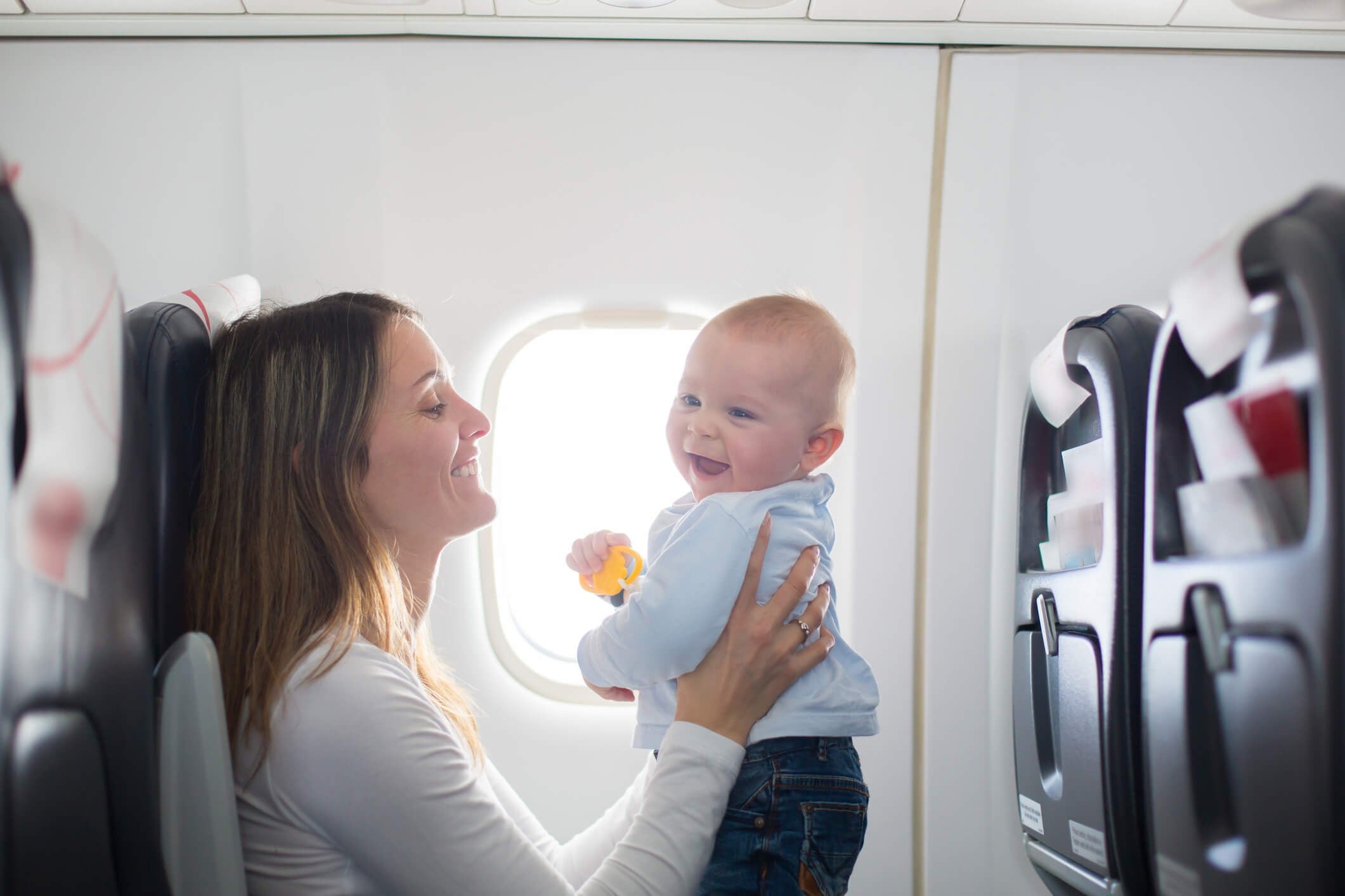 woman holding baby up in plane